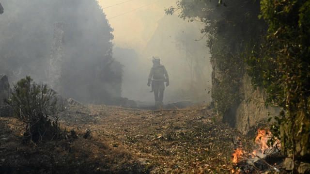Des personnes luttent contre un incendie de forêt dans le village de Vilarino, dans la municipalité de Carballeda de Avia, au nord-ouest de l'Espagne, le 17 août 2025. 