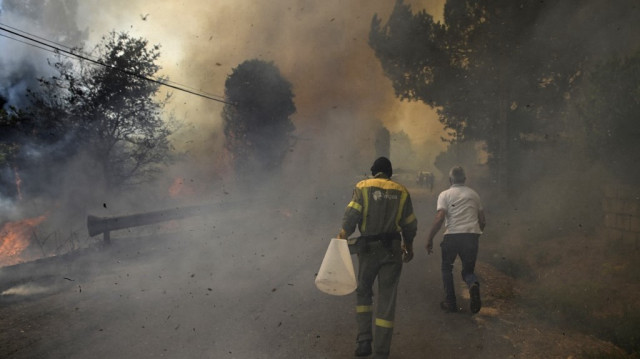 Des personnes luttent contre un incendie de forêt dans le village de Vilarino, dans la municipalité de Carballeda de Avia, au nord-ouest de l'Espagne, le 17 août 2025. 