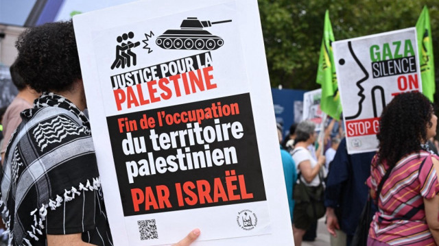 Un homme brandit une pancarte sur laquelle on peut lire "Fin de l'occupation israélienne des territoires palestiniens" alors qu'il participe à un rassemblement pour protester contre les actions d'Israël et la pénurie alimentaire qui sévit dans la bande de Gaza, à Paris, le 19 août 2025.