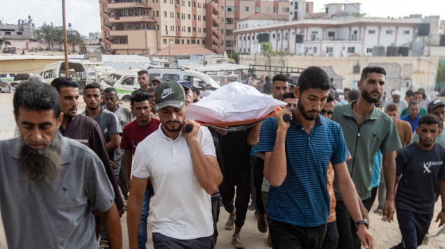 Des personnes en deuil transportent le corps d'une des victimes tuées lors du bombardement israélien nocturne d'un camp accueillant des personnes déplacées dans la région de Mawasi, à Khan Yunis, lors des funérailles organisées au complexe médical Nasser à Khan Yunis, dans le sud de la bande de Gaza, le 5 août 2025.