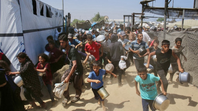 Les Palestiniens se précipitent pour faire la queue devant une cantine sociale dans le quartier de Mawasi, à Khan Yunis, dans le sud de la bande de Gaza, le 22 juillet 2025.