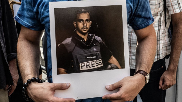 Une personne tient une photo du journaliste d'Al Jazeera Anas al-Sharif, assassiné, alors que des manifestants pro-palestiniens participent à une "Marche pour l'humanité" contre la crise humanitaire à Gaza, le 16 août 2025, à New York.