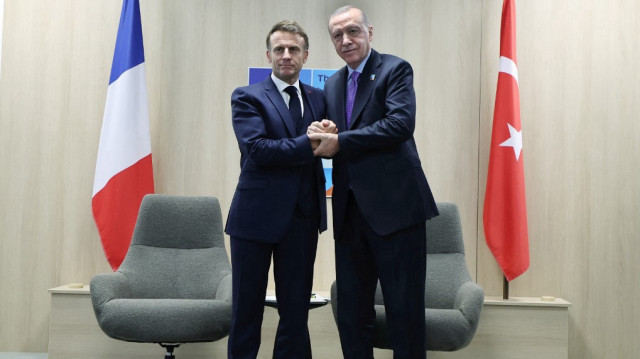 Cette photo prise et diffusée par le service de presse de la présidence turque le 25 juin 2025 montre le président français Emmanuel Macron (à gauche) serrant la main du président turc Recep Tayyip Erdogan lors de leur rencontre en marge du sommet de l'Organisation du traité de l'Atlantique Nord (OTAN) à La Haye.