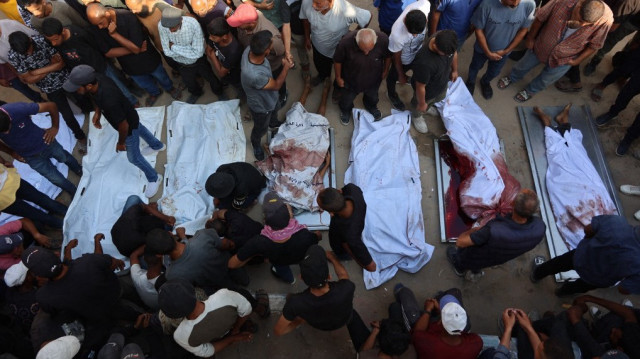 Des Palestiniens pleurent leurs proches, tués lors de frappes israéliennes, avant leurs funérailles à l'hôpital Al-Shifa de Gaza, le 21 août 2025.