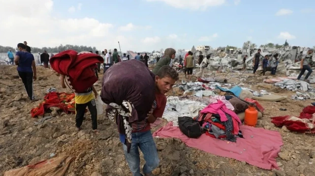 Des Palestiniens déplacés transportent leurs biens après une frappe israélienne sur un camp de personnes déplacées à Deir el-Balah, dans le centre de la bande de Gaza, le 21 août 2025. Israël a pilonné la ville de Gaza et ses environs pendant la nuit, ont déclaré des habitants le 20 août, alors que l'armée annonçait avoir pris les premières mesures pour s'emparer du dernier bastion important du Hamas.