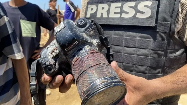 Un journaliste tient l'appareil photo couvert de sang appartenant à la photojournaliste palestinienne Mariam Dagga, une journaliste qui travaillait en freelance pour l'AP depuis le début de la guerre et qui a été tuée lors d'une frappe israélienne sur l'hôpital Nasser à Khan Yunis, dans le sud de la bande de Gaza, lors de ses funérailles le 25 août 2025.