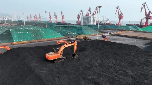 Des pelleteuses empilent du charbon au terminal charbonnier du port de Lianyungang, dans la province chinoise du Jiangsu, à l'est du pays, le 13 juillet 2025.