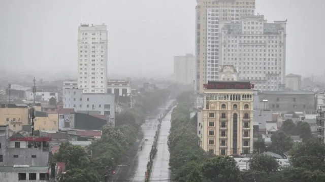 Quelques véhicules circulent sur une route presque déserte dans la ville de Vinh, province de Nghe An, le 25 août 2025, alors que le typhon Kajiki devrait toucher terre. 