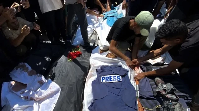 Des personnes pleurent devant les corps de journalistes palestiniens tués lors d'une frappe israélienne sur l'hôpital Nasser, avant leurs funérailles à Khan Younes, dans le sud de la bande de Gaza, le 25 août 2025.