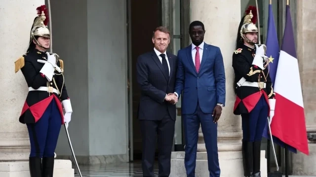 Le président français Emmanuel Macron (à gauche) serre la main du président sénégalais Bassirou Diomaye Faye à leur arrivée pour une réunion à l'Élysée, à Paris, le 27 août 2025.