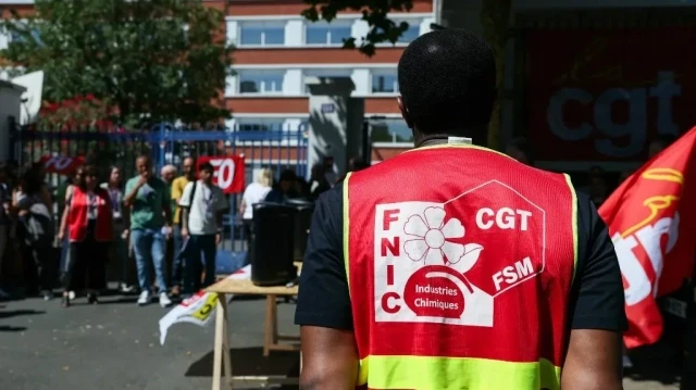 Un employé portant une veste du syndicat CGT participe à un rassemblement devant le siège de l'entreprise pharmaceutique française Sanofi à Maisons-Alfort, au sud-est de Paris, le 10 juillet 2025, organisé par le syndicat Confédération générale du travail (CGT).