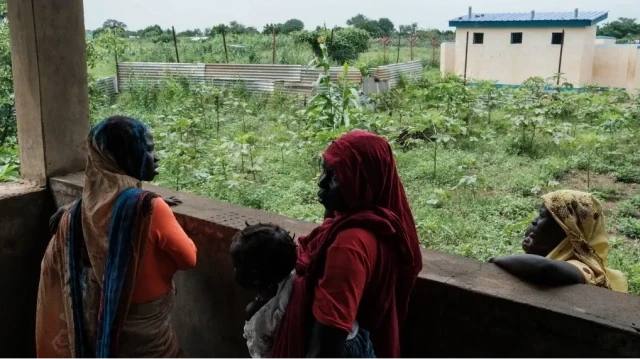 Un groupe de femmes attend avec ses enfants pour être pris en charge près d'un centre d'accueil pour les nouveaux arrivants du Soudan au camp de réfugiés de Dorro, à Maban, le 20 août 2025.