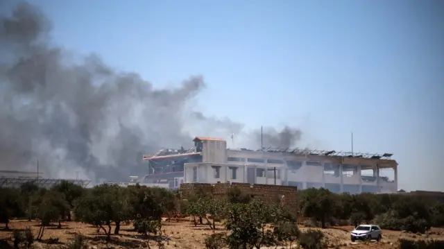 Une colonne de fumée s'élève à la suite d'une explosion à Maarrat Misrin, dans le nord de la province d'Idlib, en Syrie, le 24 juillet 2025.