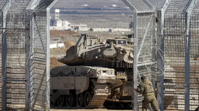 Un soldat de l'armée israélienne ferme la porte derrière un char de combat principal Merkava qui a franchi la clôture barbelée pour pénétrer dans la zone tampon patrouillée par l'ONU séparant les forces israéliennes et syriennes dans les hauteurs du Golan, près du poste de contrôle de l'ONU à Quneitra, le 2 mars 2025.