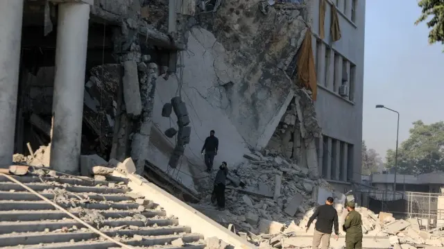 Des membres des forces de sécurité syriennes évaluent les dégâts à l'intérieur du complexe fortement endommagé du quartier général de l'armée syrienne et du ministère de la Défense à Damas, à la suite des frappes israéliennes du 16 juillet 2025.
