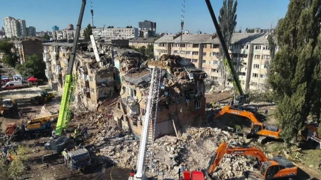 Cette photographie prise et diffusée par les services d'urgence ukrainiens le 28 août 2025 montre des sauveteurs menant une opération de recherche et de sauvetage dans et autour d'un immeuble résidentiel fortement endommagé lors d'une attaque à grande échelle menée par des drones et des missiles russes contre Kiev, dans le cadre de l'invasion russe de l'Ukraine.