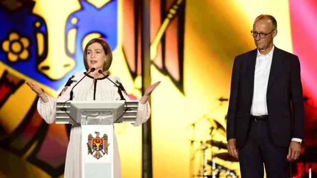 Le chancelier allemand Friedrich Merz (à droite) écoute la présidente moldave Maia Sandu prononcer un discours à l'occasion du 34e anniversaire de l'indépendance du pays, à Chisinau, le 27 août 2025.