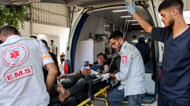 Un jeune Palestinien, blessé par balle alors qu'il attendait l'arrivée des camions d'aide humanitaire dans le nord de la bande de Gaza via le passage frontalier de Zikim, est descendu d'une ambulance après son arrivée à l'hôpital Shifa de Gaza pour y recevoir des soins médicaux, le 27 juillet 2025.