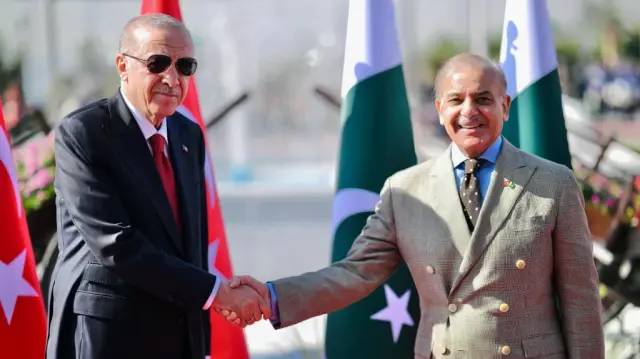Cette photo prise et diffusée par le cabinet du Premier ministre pakistanais le 13 février 2025 montre le président turc Recep Tayyip Erdogan (à gauche) serrant la main du Premier ministre pakistanais Shehbaz Sharif avant d'inspecter la garde d'honneur lors de la cérémonie d'accueil à la résidence du Premier ministre à Islamabad.