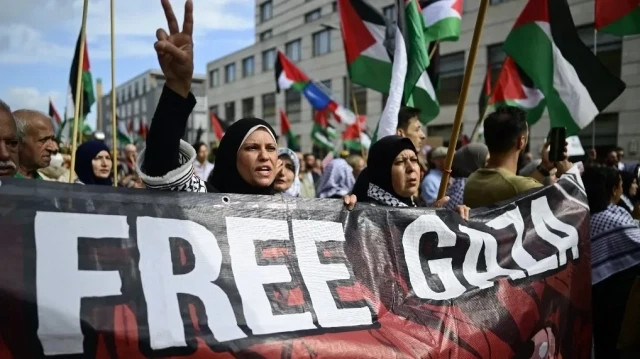 Une manifestante pro-palestinienne fait le signe de la victoire en brandissant une banderole sur laquelle on peut lire "Free Gaza" lors d'une manifestation près de l'ambassade d'Égypte à Berlin, le 25 juillet 2025.