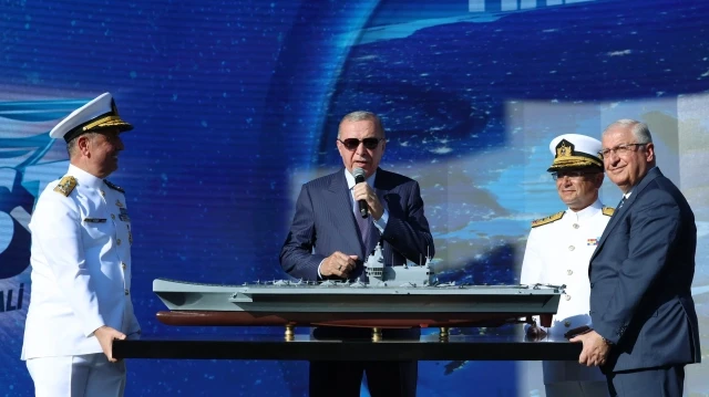 Le président turc Recep Tayyip Erdogan devant une maquette du futur porte-avions turc MUGEM, à Istanbul, le 28 aoüt 2025.