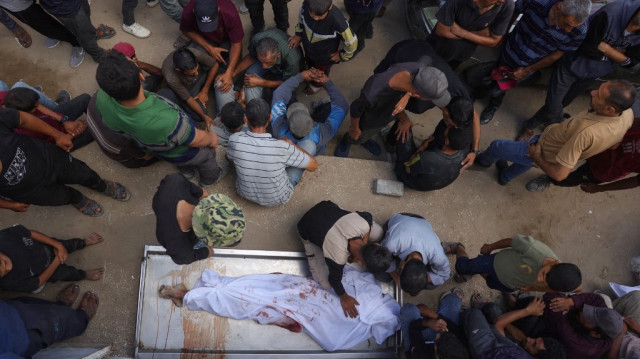 Des Palestiniens pleurent devant le corps d'un homme tué la veille alors qu'il attendait de l'aide à l'hôpital Al-Shifa de Gaza, le 31 juillet 2025.