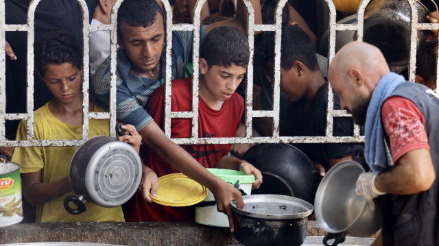 Des Palestiniens attendent leur repas dans une cantine sociale du quartier de Mawasi, à Khan Yunis, dans le sud de la bande de Gaza, le 22 juillet 2025.