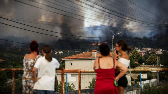 Des habitants regardent un feu de forêt brûler dans les collines environnantes à Gondomar, dans le nord du Portugal, le 29 juillet 2025.