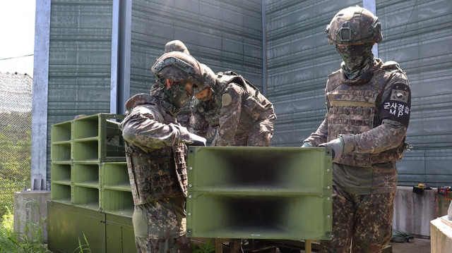 Des soldats sud-coréens en train de retirer des haut-parleurs installés pour des émissions de propagande près de la zone démilitarisée séparant les deux Corées, dans un lieu non divulgué en Corée du Sud,  le 4 août 2025.