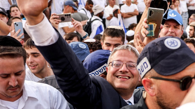 Le ministre israélien de la Sécurité nationale et homme politique d'extrême droite Itamar Ben-Gvir, entouré de policiers israéliens, salue d'autres militants de droite rassemblés devant la porte de Damas de la vieille ville fortifiée de Jérusalem, le 26 mai 2025.