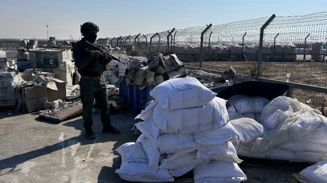 Un soldat israélien monte la garde à côté d'une aide humanitaire au poste-frontière de Kerem Shalom, entre le sud d'Israël et la bande de Gaza, le 27 juillet 2025.