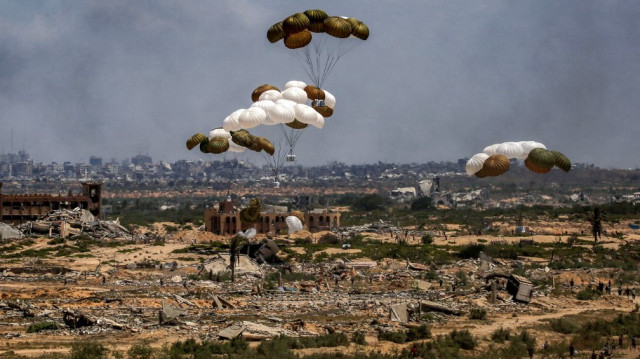 Les Palestiniens se précipitent sur les lieux alors que des palettes d'aide humanitaire sont parachutées après avoir été larguées depuis un avion militaire au-dessus de Nuseirat, dans le centre de la bande de Gaza, lors d'une mission de largage aérien au-dessus du territoire palestinien assiégé par Israël, le 5 août 2025.