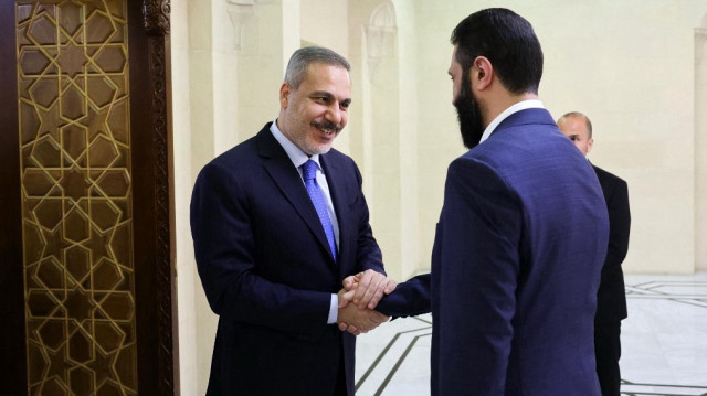 Cette photo diffusée par le service de presse du ministère turc des Affaires étrangères montre le ministre turc des Affaires étrangères Hakan Fidan (à gauche) accueilli par le président par intérim syrien Ahmed al-Sharaa à Damas, le 13 mars 2025.