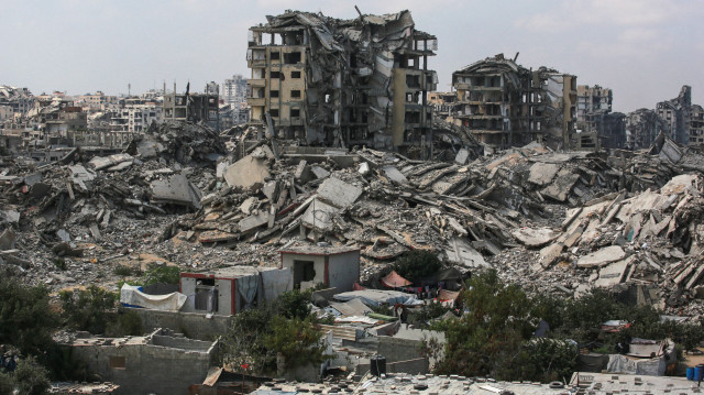 Des bâtiments détruits par les frappes israéliennes entourent des abris de fortune pour les Palestiniens déplacés à Gaza City, le 8 août 2025. L'armée israélienne va "prendre le contrôle" de Gaza City dans le cadre d'un nouveau plan approuvé par le cabinet de sécurité du Premier ministre, ce qui a déclenché une vague de critiques tant à l'intérieur qu'à l'extérieur du pays.