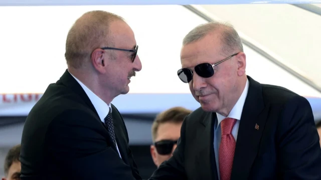 Cette photo prise et diffusée par le service de presse de la présidence turque le 19 juin 2025 montre le président turc Recep Tayyip Erdogan (à droite) serrant la main du président azerbaïdjanais Ilham Aliyev lors de la cérémonie d'inauguration des 250 000 logements construits après le tremblement de terre à Kahramanmaras.