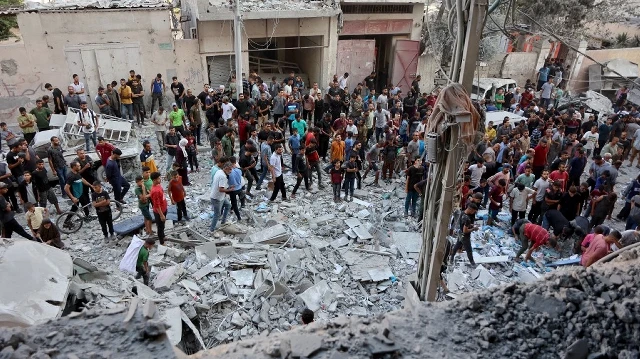Des Palestiniens se rassemblent pour chercher des survivants sur le site d'une frappe israélienne qui a touché plusieurs bâtiments dans le quartier Al-Rimal de la ville de Gaza, le 30 août 2025. La Croix-Rouge a averti le 30 août que toute tentative israélienne d'évacuer la ville de Gaza mettrait les résidents en danger, alors que l'armée israélienne a renforcé son siège sur la zone avant une offensive prévue.