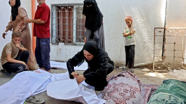 Une Palestinienne pleure sur le corps recouvert d'un linceul d'un enfant tué lors d'une frappe israélienne sur une boulangerie de fortune installée dans une tente rue Al-Nassr à Gaza, le 30 août 2025, à l'hôpital Al-Shifa.
