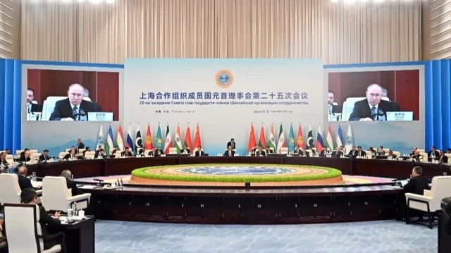 Sur cette photo de groupe diffusée par l'agence d'État russe Sputnik, le président russe Vladimir Poutine (à l'écran) assiste au sommet de l'Organisation de coopération de Shanghai (OCS) à Tianjin, le 1er septembre 2025.