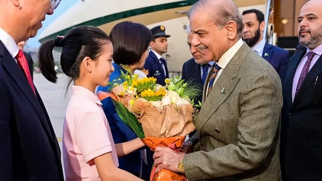 Sur cette photo prise le 30 août 2025 et diffusée par le Département d'information de presse du Pakistan (PID), le Premier ministre pakistanais Shehbaz Sharif (au centre à droite) reçoit un bouquet de fleurs à son arrivée à l'aéroport de Tianjin, à la veille du sommet de l'Organisation de coopération de Shanghai (OCS).