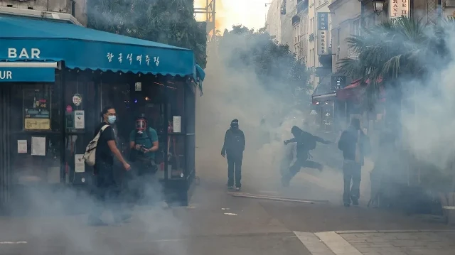 Des manifestants se tiennent debout dans la fumée des gaz lacrymogènes lors d'affrontements avec des manifestants près de la place Joachim-du-Bellay, lors d'une manifestation dans le cadre du mouvement de protestation "Bloquons tout", à Paris, le 10 septembre 2025.