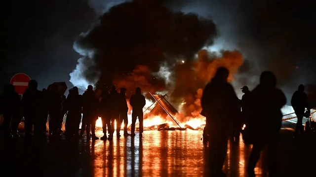 Des manifestants brûlent des objets alors qu'ils se rassemblent pour bloquer le pont du Viaduc de Calix lors d'une manifestation dans le cadre du mouvement de protestation "Bloquons tout", à Caen, dans le nord-ouest de la France, le 10 septembre 2025.