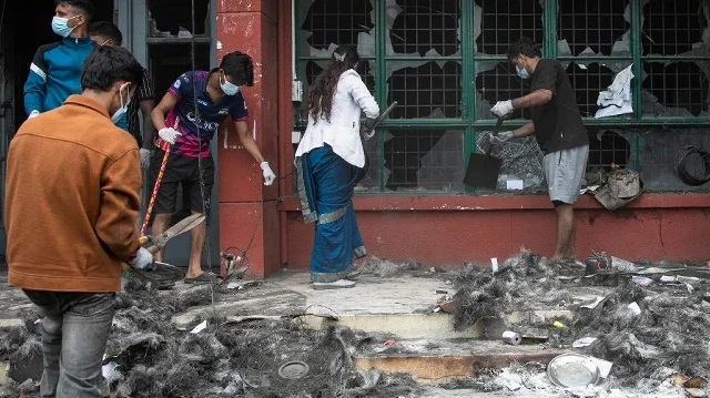 Des bénévoles nettoient les décombres et les ravages causés par l'incendie du bâtiment administratif du Département de la gestion des transports (DOTM) du Népal à Katmandou, le 10 septembre 2025. 