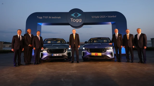 Le président turc Recep Tayyip Erdogan pose pour une photo entre deux modèles du nouveau TOGG, le T10F, dont l'un lui a été remis au bureau de Dolmabahçe à Istanbul, en Türkiye, le 12 septembre 2025.