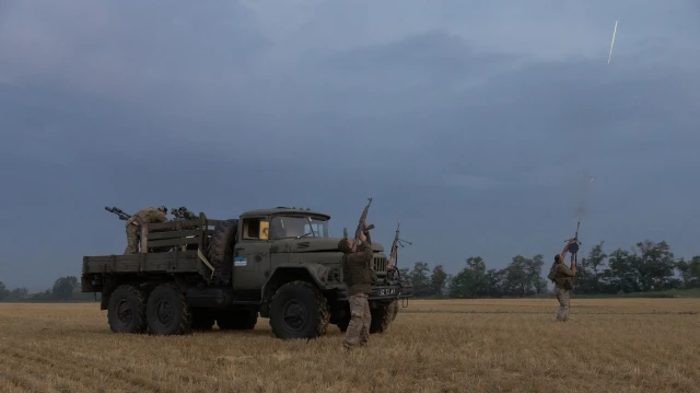 Des militaires ukrainiens de la 59e brigade mobile de défense aérienne tirent avec leurs armes sur un drone russe lors d'une attaque aérienne près de Pavlograd, dans la région de Dnipropetrovsk, le 19 juillet 2025, dans le contexte de l'invasion russe de l'Ukraine.