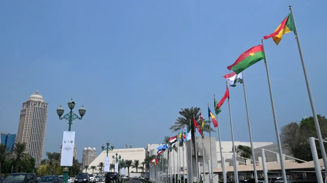 Des drapeaux flottent le long de la route menant à l'hôtel où se tiendra le prochain sommet arabo-islamique, organisé pour discuter de la récente attaque israélienne contre le Qatar, à Doha, le 14 septembre 2025.