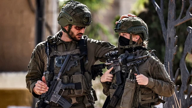 Des soldats de l'armée israélienne prennent position à l'entrée du camp de réfugiés d'al-Amari, dans la ville occupée de Ramallah, en Palestine occupée, lors d'un raid militaire mené le 14 septembre 2025.