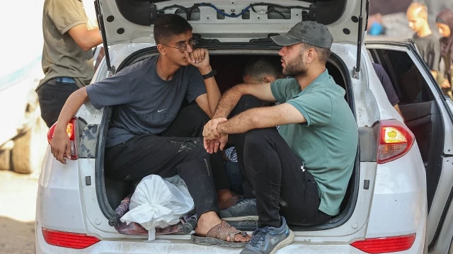 Des Palestiniens s’assoient dans le coffre d’une voiture aux côtés du corps d’un proche tué lors des premières frappes israéliennes, à l’hôpital al-Shifa de Gaza, avant son inhumation le 8 septembre 2025.