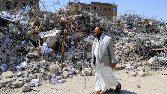 Un homme passe devant les décombres d'un bâtiment, quelques jours après sa destruction par une frappe israélienne dans la capitale yéménite Sanaa, contrôlée par les Houthis, le 14 septembre 2025.