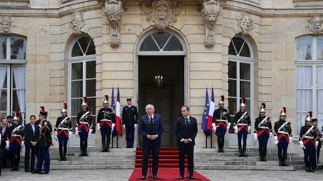 Le Premier ministre sortant français François Bayrou (à gauche), entouré du nouveau Premier ministre français et ancien ministre des Forces armées Sébastien Lecornu (à droite), prononce un discours lors de la cérémonie de passation de pouvoir à l'Hôtel Matignon à Paris, le 10 septembre 2025.