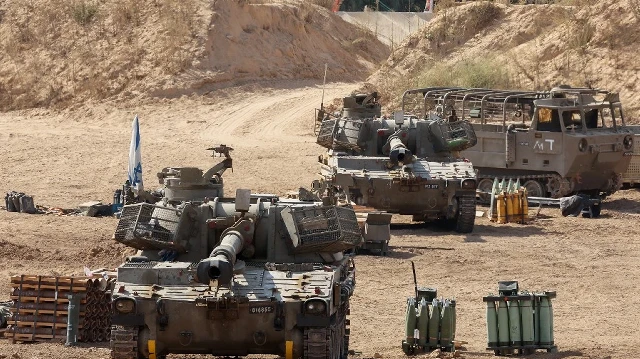 Cette photo prise depuis un poste situé à la frontière israélienne avec la bande de Gaza montre des unités d'artillerie mobiles israéliennes déployées près de la barrière frontalière avec le territoire palestinien assiégé, le 17 septembre 2025.